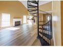 Bright living room with fireplace, light wood floors, and a unique spiral staircase leading to the upper level at 1960 Banks Way, Atlanta, GA 30349