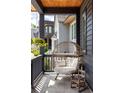 Inviting porch features a hanging chair and hanging plants creating a cozy outdoor space at 1126 Mado Loop, Chattahoochee Hills, GA 30268