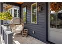 Inviting porch features a hanging chair and hanging plants creating a cozy outdoor space at 1126 Mado Loop, Chattahoochee Hills, GA 30268