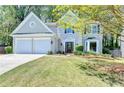 Beautiful home showcasing a two-car garage, lush lawn, and well-maintained landscape at 335 Wyehwood Ct, Alpharetta, GA 30022