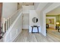 Bright foyer featuring wood floors, a staircase, and an open doorway to a connected room at 335 Wyehwood Ct, Alpharetta, GA 30022