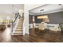 Elegant dining room featuring wood floors, staircase, decorative lighting, and a glass-top table with seating at 1442 Valley Glen Way, Dunwoody, GA 30338