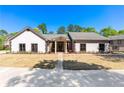 Exterior elevation of a charming home with stone accents, a well-maintained lawn, and mature trees at 2320 Copper Trail Ln, Buford, GA 30519