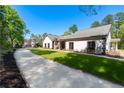 Well-maintained home exterior features lush lawn, long driveway, and attractive landscaping at 2320 Copper Trail Ln, Buford, GA 30519
