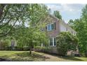 A beautiful brick home with lush green lawn, mature trees, and manicured shrubbery lining the front at 553 Augusta Dr, Canton, GA 30115