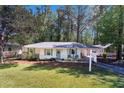 Inviting ranch-style home with well-manicured lawn and charming front porch seating area at 705 Stewart Nw Cir, Marietta, GA 30064