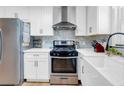 Modern kitchen with white cabinets, stainless steel appliances, and stylish tile backsplash at 705 Stewart Nw Cir, Marietta, GA 30064