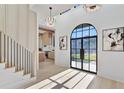 Bright foyer with a soaring ceiling, staircase, modern light fixture, and an arched steel and glass front door at 115 Nova Ln, Roswell, GA 30075