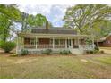 Charming brick home featuring a welcoming front porch, a well-manicured lawn, and an inviting facade at 177 Fairview Dr, Fairburn, GA 30213