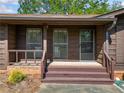Welcoming front porch featuring brick accents and wood paneling at 4927 Bedell Ne Rd, Roswell, GA 30075