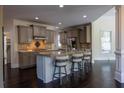Open kitchen with granite countertops, stainless appliances, custom cabinetry, and a central island with bar stool seating at 610 Big Bend Trl, Sugar Hill, GA 30518