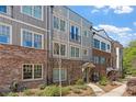 Townhome exteriors featuring brick accents, neutral siding, and well-manicured landscaping at 6135 Redwine St, Norcross, GA 30071
