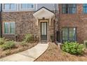 Brick facade with a black front door and small covered porch leading to a walkway at 6135 Redwine St, Norcross, GA 30071