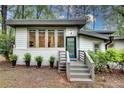 Inviting front entrance featuring a gray brick foundation, blue accent door and lovely plantings at 1587 Wainwright Se Dr, Atlanta, GA 30316