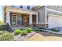 A two-story house with stone accents and a landscaped front yard with a green lawn at 625 Lorimore Pass, Canton, GA 30115
