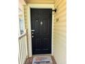 Charming front door with 'Welcome' mat, white trim, and exterior light fixture at 1504 Augusta Se Dr, Marietta, GA 30067