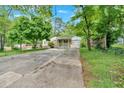 Charming single-story home featuring a covered porch and a spacious driveway, surrounded by mature trees and lush greenery at 1728 Line St, Decatur, GA 30032