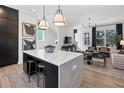 Open-concept kitchen featuring a large island with seating, sleek black cabinets, and hardwood floors at 946 Hughley Circle # 98, Atlanta, GA 30316