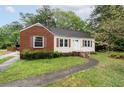 Well-maintained home with light siding, brick accents, and a sidewalk leading to the front door at , Tucker, GA 30084