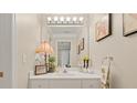 Bathroom featuring a large mirror, stylish lighting, and vanity with decorative accessories at 1420 Lockridge Dr, Cumming, GA 30041