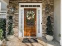 Charming front door with stone surround, decorative wreath, and sidelights at 1420 Lockridge Dr, Cumming, GA 30041