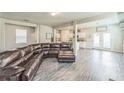 Spacious living room featuring hardwood floors and a large comfortable leather sectional sofa and an open concept at 2142 Theberton Trl, Locust Grove, GA 30248