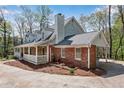 Spacious home boasts a brick and stone exterior with a wraparound porch and a convenient carport at 9055 Carroll Manor Dr, Sandy Springs, GA 30350
