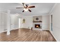 Inviting living room featuring a cozy fireplace, ceiling fan, and updated flooring at 9055 Carroll Manor Dr, Sandy Springs, GA 30350