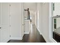 Hallway with beautiful hardwood flooring, white walls, and lots of natural light at 627 Skytop Dr, Cumming, GA 30040