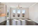 Living room featuring hardwood floors, white walls, three large windows, and ceiling fan at 627 Skytop Dr, Cumming, GA 30040