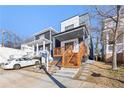 Modern home with a covered front porch, wooden stairs, and well-maintained lawn at 906 Mcdaniel St, Atlanta, GA 30310