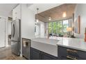 Modern kitchen with stainless steel appliances, farmhouse sink and view into the living space at 245 N Highland Ne Ave # 220, Atlanta, GA 30307