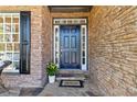 Inviting front entrance with a stylish blue door, stone accents, and a 'Welcome' mat at 2625 Cross Springs Dr, Cumming, GA 30041