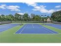 Well-maintained tennis courts with a blue and green surface, surrounded by lush greenery at 2625 Cross Springs Dr, Cumming, GA 30041