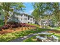 Exterior view of a two-story condo with a gazebo, bench seating, and lush landscaping at 305 Summit North Ne Dr # 305, Atlanta, GA 30324