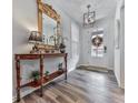 Elegant foyer featuring wood-look floors, a decorative mirror, and a stylish pendant light, creating a welcoming entrance at 6380 Cortland Walk, Alpharetta, GA 30005