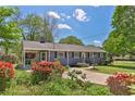 Landscaped front yard showcasing vibrant red flowers enhancing the curb appeal of this cozy home at 3326 Chappel Lane, Peachtree Corners, GA 30360