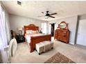 Inviting bedroom featuring a carved wooden bed, neutral carpet, and a ceiling fan for added comfort at 5485 Mountain Top Pl, Cumming, GA 30041