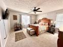 Cozy bedroom with a wooden bed frame, ceiling fan, and decorative accents, creating a warm atmosphere at 5485 Mountain Top Pl, Cumming, GA 30041