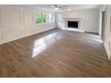 Sun-filled living room featuring hardwood floors, a fireplace, and white trim at 8608 Creekview Ct, Douglasville, GA 30135