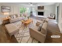 Bright living room featuring hardwood floors, a fireplace, and neutral-toned furniture at 8608 Creekview Ct, Douglasville, GA 30135
