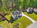 Aerial view of home with a large front yard, mature trees, and a long driveway at 1961 Flowering Dr, Grayson, GA 30017