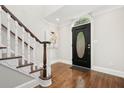 Bright entryway featuring hardwood floors, staircase, and a black front door with a decorative oval window at 1183 Woods Ne Cir, Atlanta, GA 30324