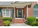 Close up of the front door with brick steps, stylish accents, and well-maintained landscaping at 2545 Amberbrook Ln, Grayson, GA 30017