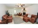 A bright living room with tile floor, a fireplace, ceiling fan, and comfortable leather seating at 2896 Lakemont Sw Dr, Marietta, GA 30060
