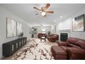 A spacious living room featuring a fireplace, ceiling fan, plush seating, and elegant decor at 2896 Lakemont Sw Dr, Marietta, GA 30060