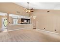 Spacious living room with neutral carpeting, ceiling fan, and lots of natural light at 65 Woodside Ct, Mcdonough, GA 30253