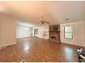Spacious living room featuring a stone fireplace, neutral paint, and ample natural light at 1228 Reilly Ln, Clarkston, GA 30021