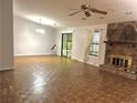 Spacious living room featuring a stone fireplace, neutral paint, and ample natural light at 1228 Reilly Ln, Clarkston, GA 30021