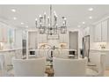 Open concept kitchen with white cabinets, stainless steel appliances, and an elegant chandelier over the island at 2718 Byess Ct, Marietta, GA 30064